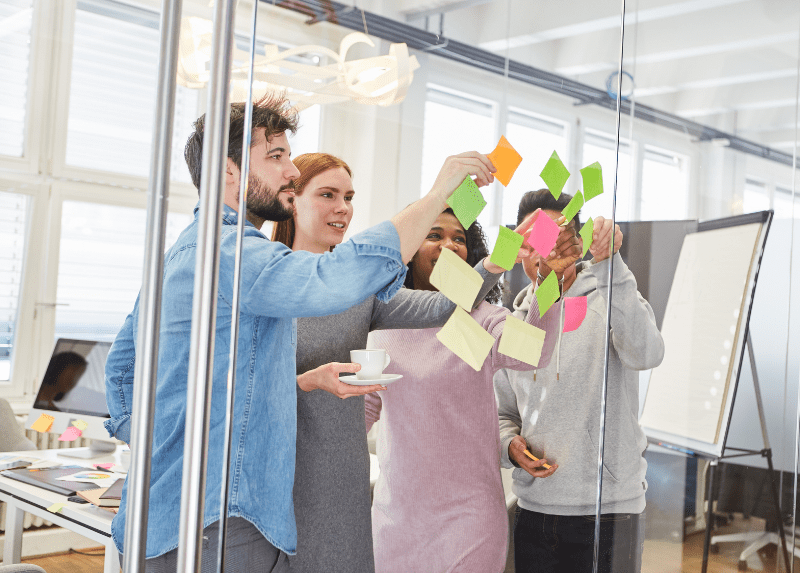 Group moving post it notes on a window